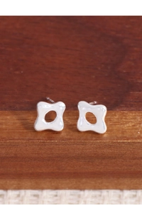Vue macro des boucles d'oreilles étoiles évidées en argent S925 poli avec effet miroir