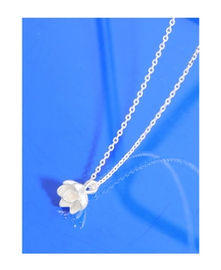 Dettaglio macro della collana con ciondolo a forma di loto in argento sterling 925 lucido