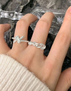Detailed view of S925 sterling silver twisted knot and woven hollow open rings on model