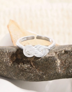 Macro detail of S925 sterling silver stamp on multilayer criss-cross knot ring