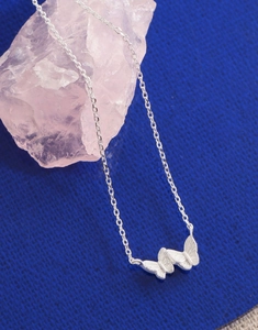 Detail of S925 sterling silver butterfly pendant necklace over pink quartz stone