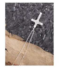 Macro detail of S925 sterling silver cross necklace with sparkling zircon pavé