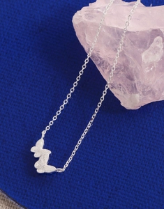 Macro detail of S925 sterling silver butterfly necklace with textured matte finish