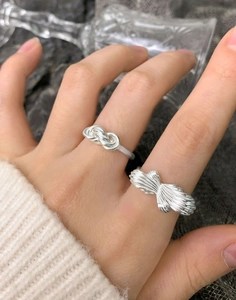 Close-up of S925 sterling silver layered cross ring set with radial texture on fingers