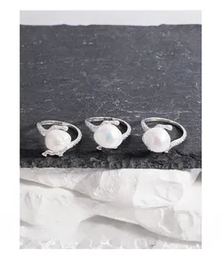 Artistic layout of S925 silver lava texture rings with baroque pearls on slate