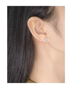 Vue macro de boucles d'oreilles clous géométriques en argent sterling S925 sur l'oreille