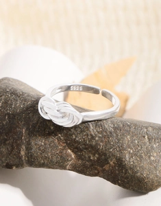 Close-up of S925 sterling silver multilayer knot ring with engraved material mark