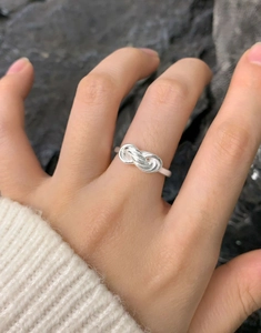Detail of S925 sterling silver multilayer intertwined ring worn with a white sweater