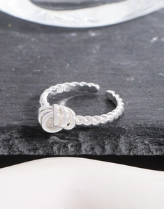 Macro shot of S925 sterling silver twisted rope ring with knot detail on black stone