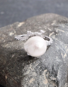 Detailed view of Baroque pearl on an irregular organic lava texture silver ring band