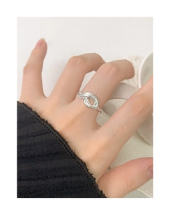 Macro detail of a silver S925 intertwined knot open ring shown on a woman finger