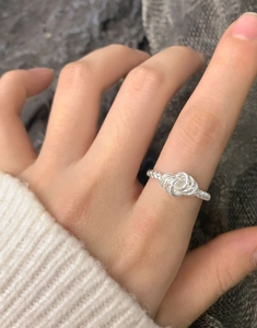 Macro shot of 925 sterling silver twisted knot ring with intricate woven texture on finger
