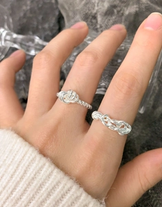 Macro shot of S925 sterling silver twist and chain rings worn by a female model