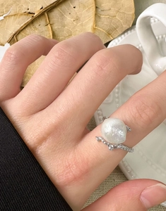 Close-up of baroque pearl ring with branch texture worn by a model in lifestyle setting