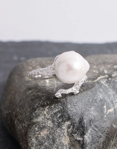 Macro detail of S925 silver baroque pearl ring with organic lava texture on stone