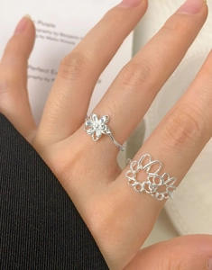 Macro shot of S925 sterling silver hollow floral rings set on model's hand