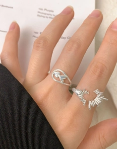 Detail of silver S925 heart rings featuring hollow oval and radial starburst designs