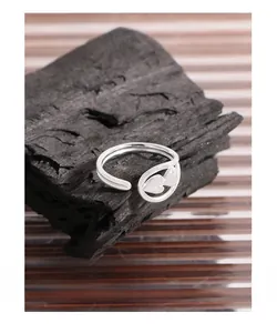 Macro shot of silver dual-heart open ring on dark charcoal with textured background
