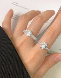 Detail of S925 silver rings with oval zircon and textured frosted band on a model's finger