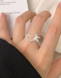 Close-up of S925 sterling silver heart ring with irregular sunburst design on finger