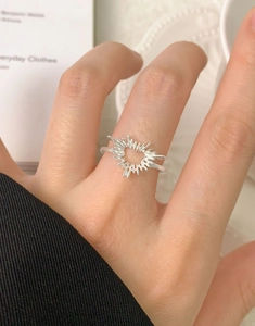 Close-up of S925 sterling silver heart ring with irregular radiant lines on model finger