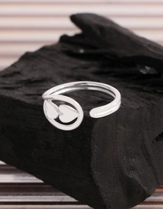 Detail of silver S925 heart open ring showing dual heart engraving on black stone