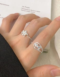 Detailed view of silver heart and flower open rings set worn on fingers for women
