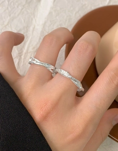 Détail de deux bagues en argent sterling S925 avec texture martelée sur une main femme
