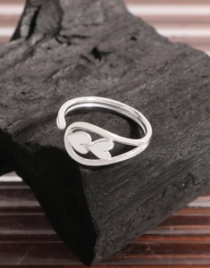 Detailed close-up of S925 sterling silver open ring with double heart design on charcoal