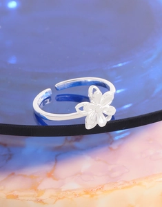 Vue macro d'une bague fleur en argent S925 sur une surface décorative en marbre