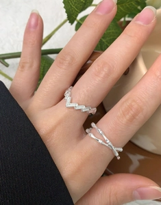 Close-up of S925 sterling silver rings with geometric wave and bamboo texture on a finger