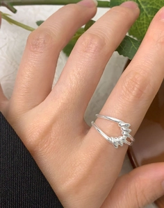 Vue détaillée d'une bague en argent 925 avec texture torsadée portée à la main