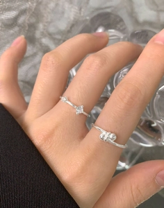 Dettaglio anello a nodo in argento S925 e anello con tre pietre di zircone su dito