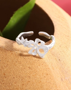 Detailed macro view of S925 sterling silver ring with flower and star on clay bowl