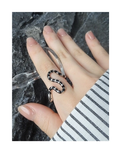 Macro detail of S925 silver snake ring with black drip enamel stripes on finger