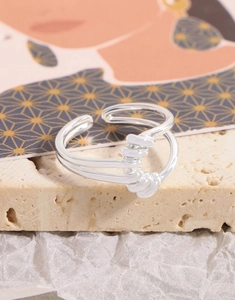 Bague nœud en argent sterling S925 sur une surface artistique en pierre beige