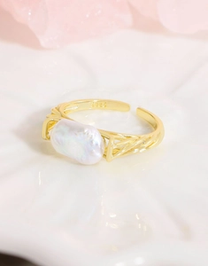 Detailed macro view of S925 sterling silver hallmark and large baroque pearl on a gold ring