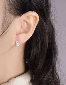 Gros plan de boucles d'oreilles cœur en argent S925 avec zircons portées par un mannequin