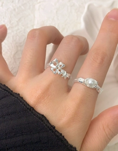 Detailed view of S925 silver ring set with hollow butterfly design and round white pearl