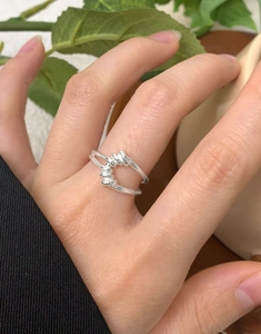 Gros plan d'une bague double anneau en argent massif S925 entrelacé portée au doigt