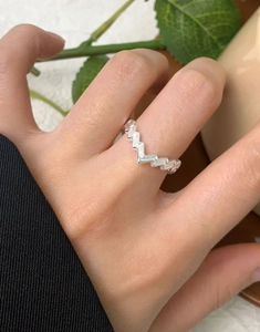 Nahaufnahme eines minimalistischen S925 Sterling Silber V-Rings an einem Frauenfinger
