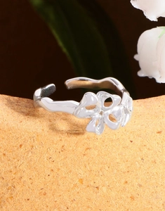 Macro view of polished S925 sterling silver bow ring on textured stone surface