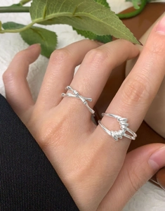 Detail of S925 sterling silver knotted and double cross rings worn on a hand