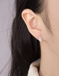 Détail d'une boucle d'oreille cœur en argent S925 avec un zircon cubique brillant