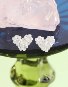 Macro shot of S925 sterling silver heart-shaped studs with detailed rose carvings
