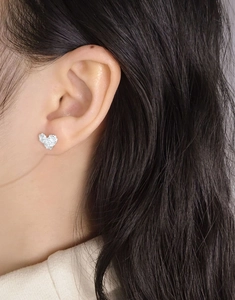 Close-up of S925 sterling silver heart earrings with textured finish on model ear