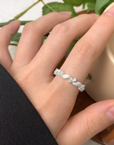 Close-up of a silver twisted zircon ring showing intricate brushed texture and gemstone detail
