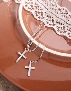 Macro shot of silver S925 cross pendant with sparkling zircon and polished finish