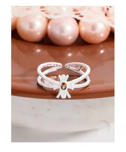 Macro shot of silver open ring with bee design and amber brown oval gemstone detail
