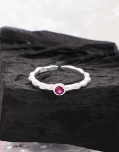 Detailed macro view of S925 sterling silver stamp on wavy pink zircon ring band